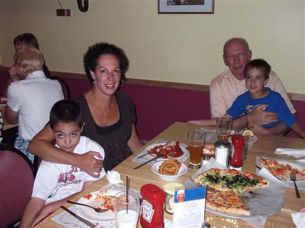 Family sitting at a table and posing for photo