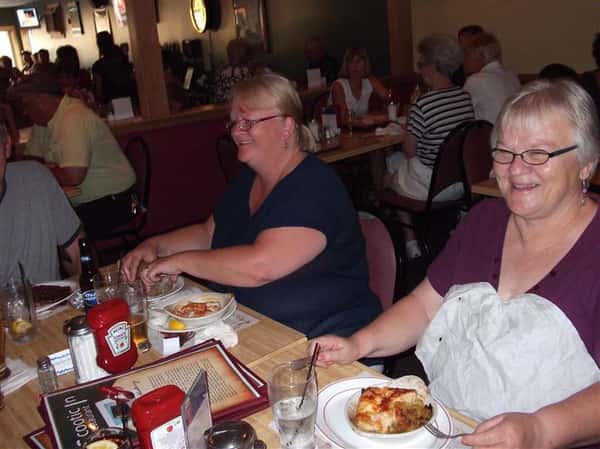 Two women eating at the table and smiling for photo