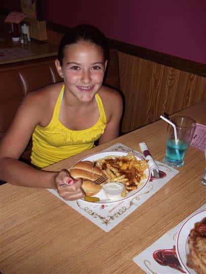 Young girl having dinner and smiling for photo