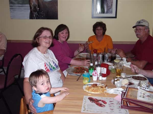 Group of people sitting at a table and posing for photo
