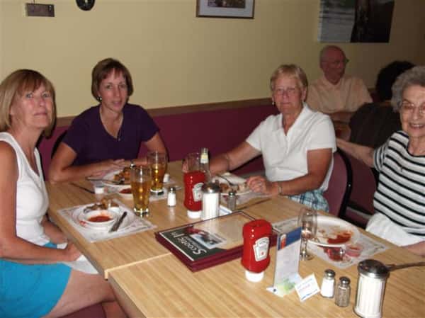 Group of people sitting at a table and posing for photo