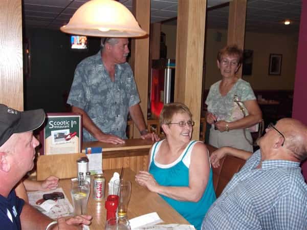 People gathered around a dining booth talking