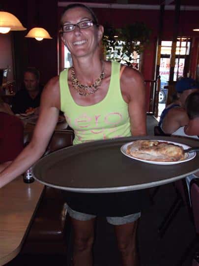 Woman serving food and smiling for photo