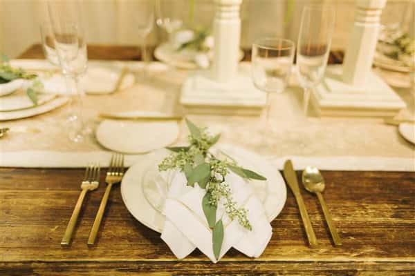 closeup of place setting with leaves on top of napkin