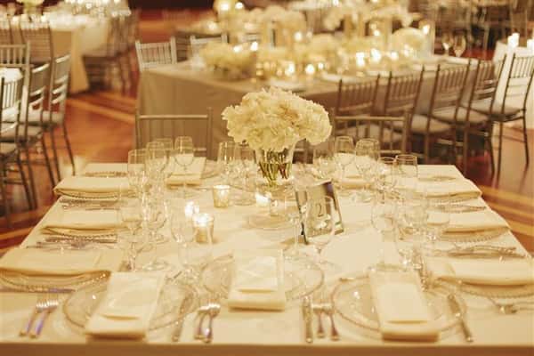 white table with place settings and a rose centerpiece