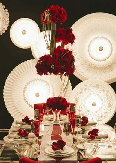 place setting of white napkins, red roses and red rose centerpieces