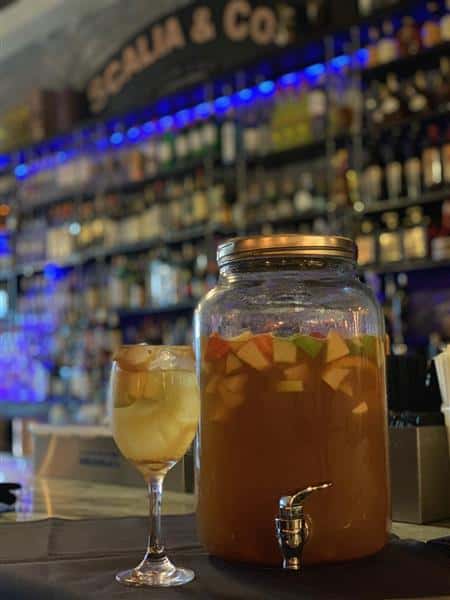 Sangria Jar next to wine glass of sangria
