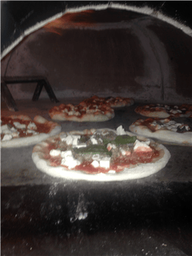 pizzas inside brick oven
