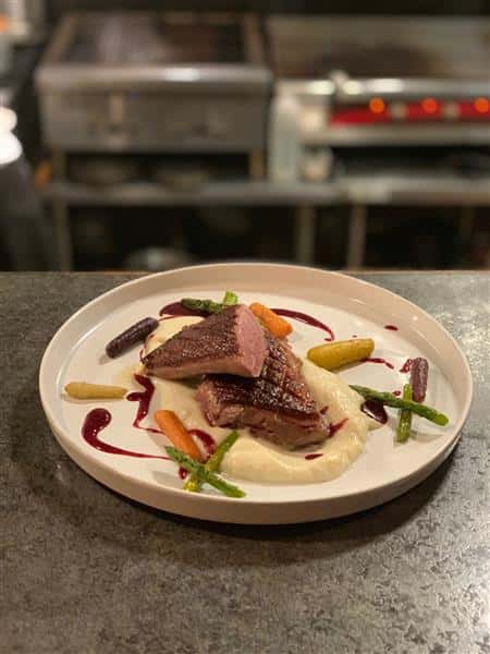 Medium Rare Steak presented with Mashed potatoes and veggies