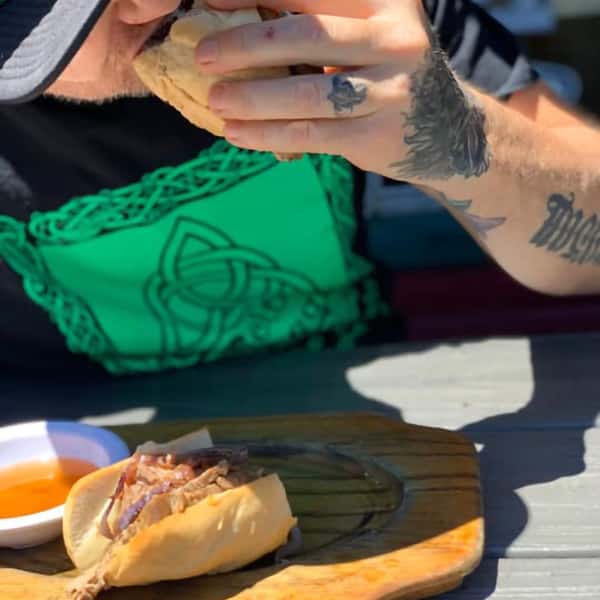 Man eating a sandwich made by The Yodeler Craft Beer & Grill