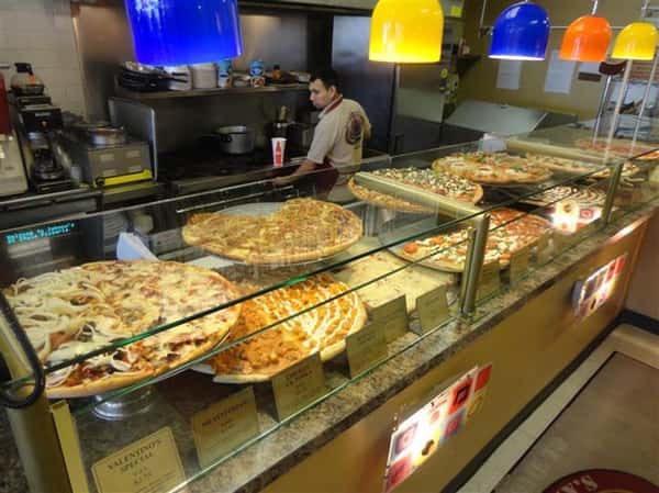 front counter with various types of pizza being displayed