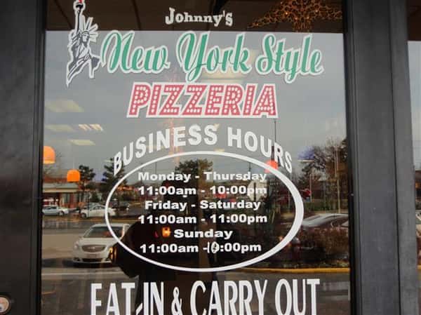 signage on the front store with johnny's new york style pizzeria logo and their business hours