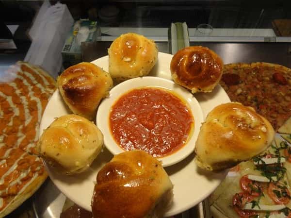 plate of garlic knot with a bowl of tomato dipping sauce