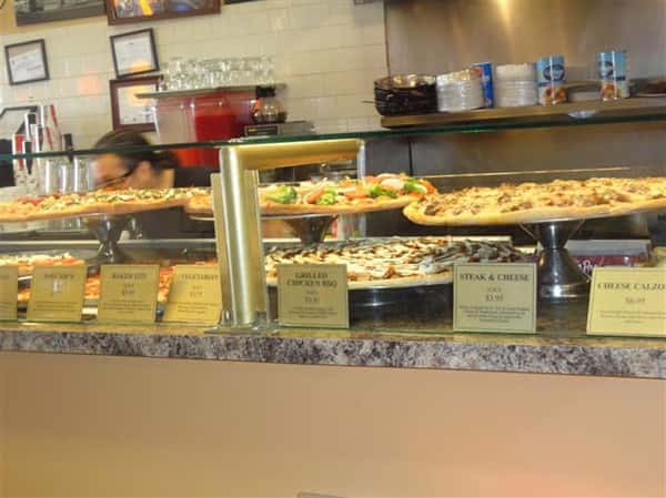 front counter with various types of pizza being displayed