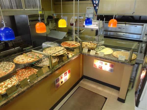 front counter with various types of pizza being displayed