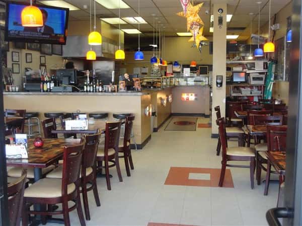 interior dining area setup with tables, chairs, a tv and a counter area