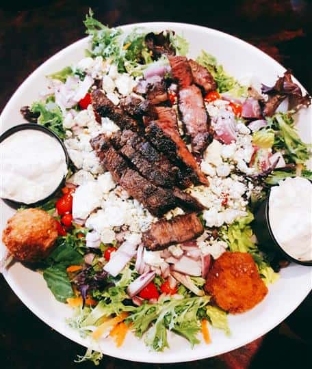 grilled steak on top of lettuce