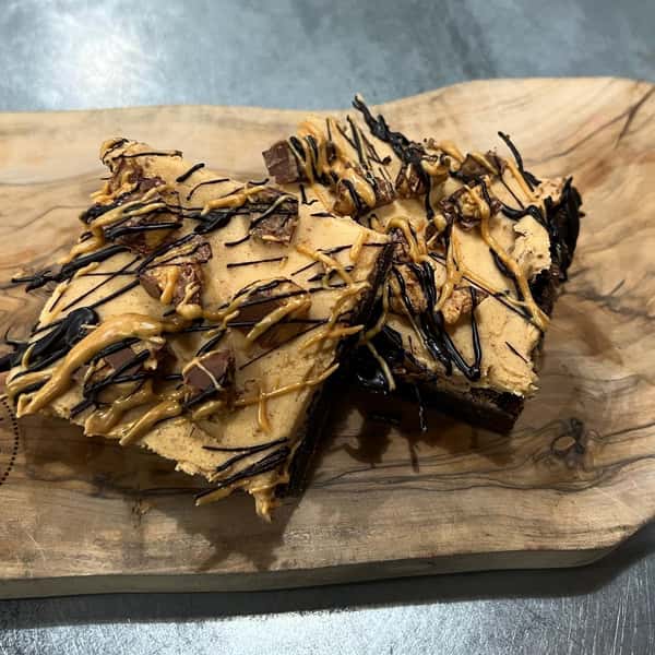 Rich chocolate brownie covered with peanut butter icing topped with Reece’s and chocolate drizzle