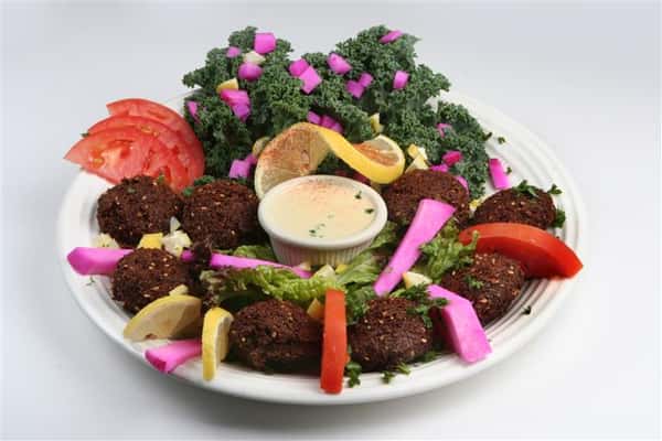 falafel plate tiooed with garnish and a side of veggies