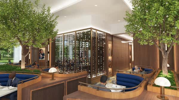 Refined dining room featuring a glass-enclosed wine display, warm wood accents, and sophisticated fine dining ambiance.
