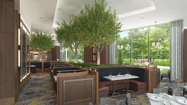 Refined main dining room featuring lush greenery, floor-to-ceiling windows, and upscale seating in a bright contemporary setting.