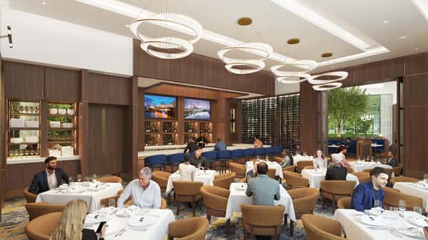Bright fine dining room with designer ring chandeliers, comfortable seating, and an elegant contemporary atmosphere.