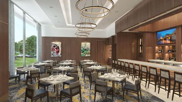 Private dining room with stylish chandelier lighting, neatly arranged tables, and an intimate upscale atmosphere for special events.