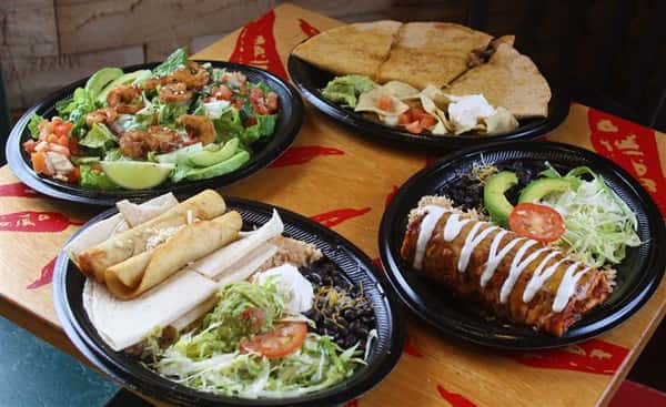 Mexican main dishes served for dinner on big plates with salad on the side