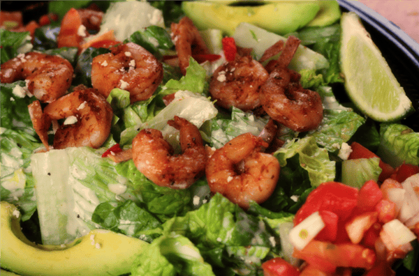 Salad topped with fried shrimp