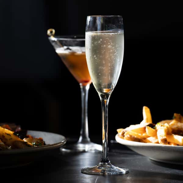 Champagne and craft cocktail served alongside crispy fries