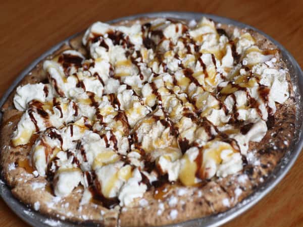 dessert pizza with whipped cream, chocolate and caramel sauces