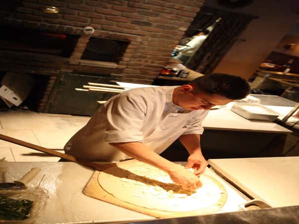 employee making pizza