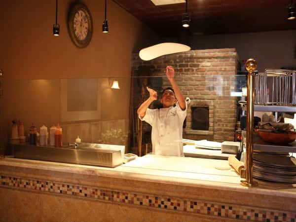 employee throwing dough in air