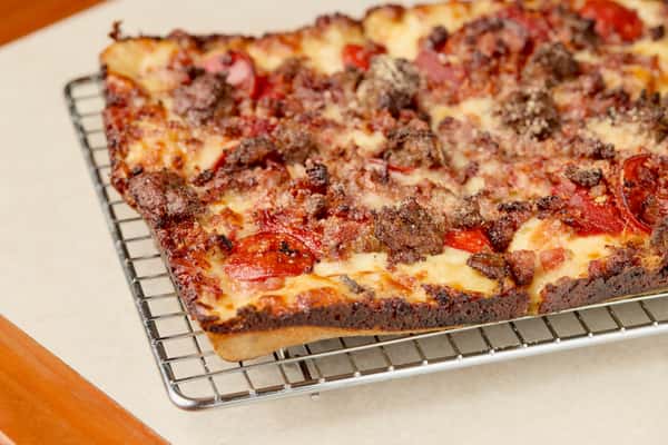 Thick crust Detroit-style deep dish pizza with melted cheese and red sauce at Como's in Ferndale.