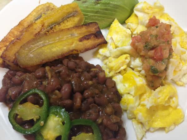 Black beans, plantains, eggs, jalapenos, and avocado on a plate