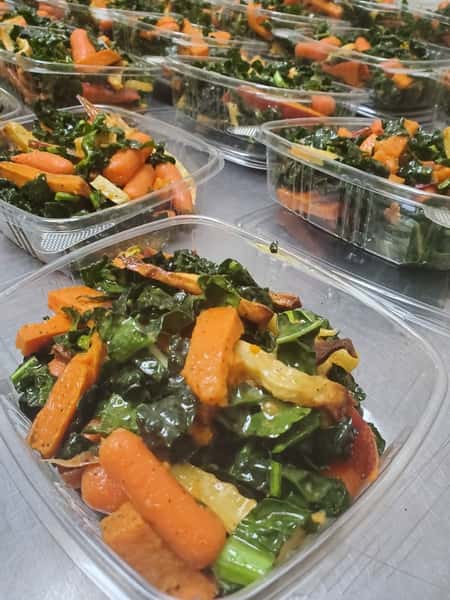 Rows of to-go containers filled with vegetable cold salads