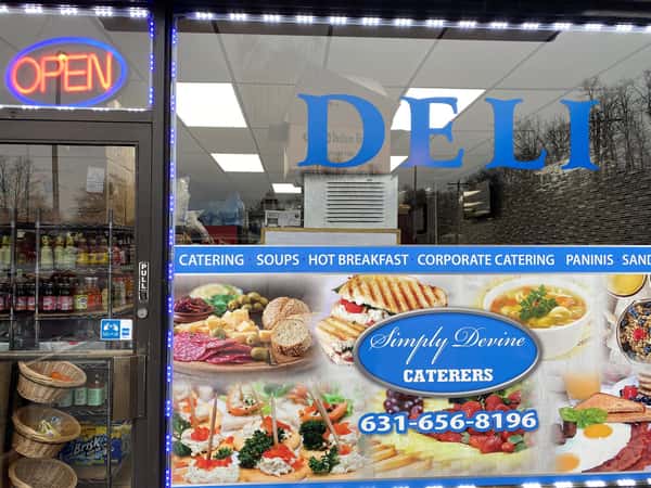 deli storefront, with pictures of food and a neon "Open" sign