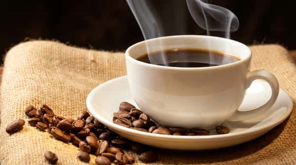 Steaming cup of coffee with coffee beans on a burlap cloth, with "Welcome to Tony's Donuts" text.