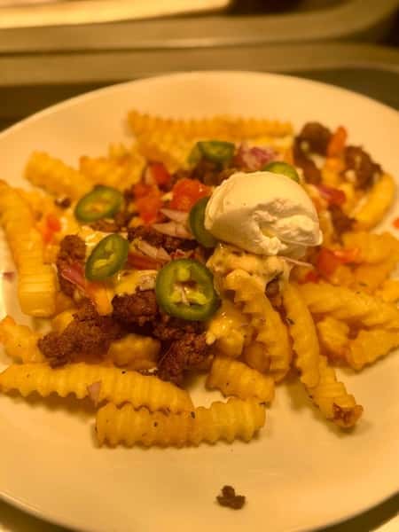 Crinkle-cut fries topped with seasoned beef, melted cheese, jalapeño slices, diced tomatoes, and a dollop of sour cream.