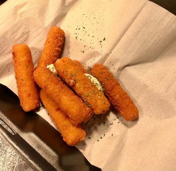 Crispy, golden-brown mozzarella sticks served on parchment paper with herb garnish, a classic appetizer perfect for casual dining.
