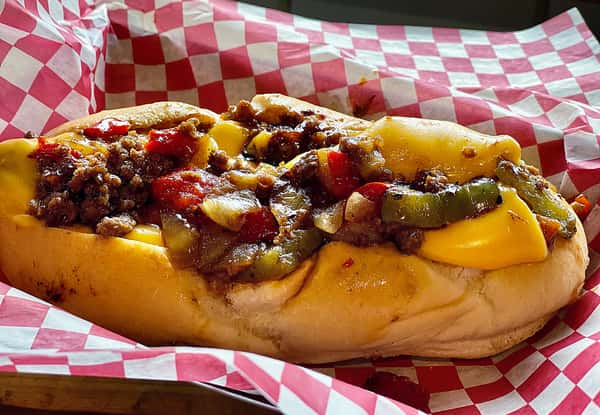 Hot dog topped with chili and melted cheese in a paper lined basket