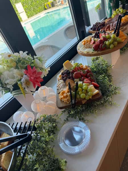 elegant catering with floral decorations displayed on a soft draped backdrop at an event venue.