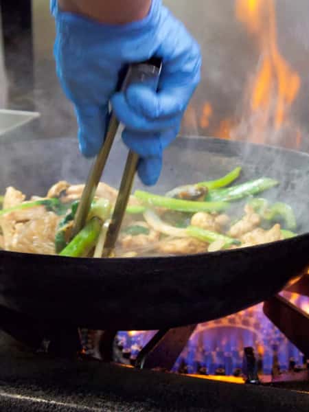person cooking in wok