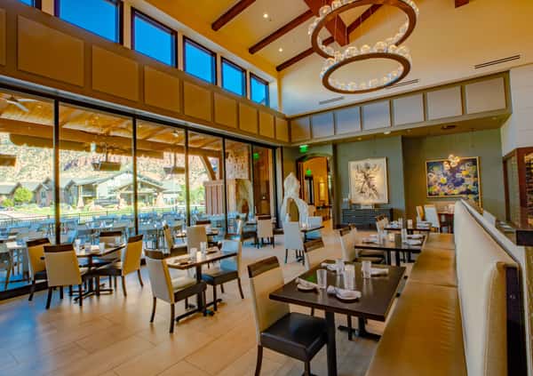 Elegant dining room at Dulivia Ristorante Italiano in Springdale, Utah, featuring soaring windows, warm natural light, and an upscale atmosphere for Italian dining near Zion National Park.