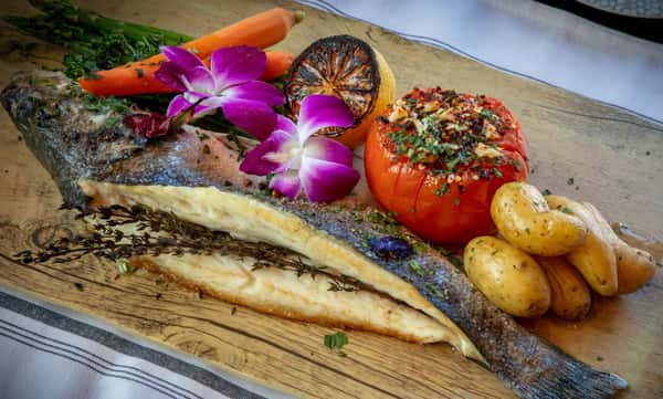 Grilled whole branzino with roasted tomatoes, baby potatoes, and fresh herbs at Dulivia Ristorante Italiano in Springdale, Utah.
