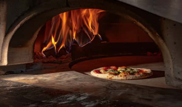 Stone-hearth pizza baking in a wood-fired oven at Dulivia Ristorante Italiano in Springdale, Utah, showcasing authentic Italian craftsmanship.