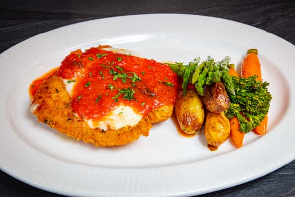 Chicken Parmesan with house-made marinara, melted mozzarella, roasted potatoes, and broccolini at Dulivia Ristorante Italiano in Springdale, Utah.