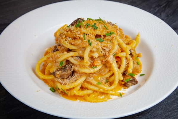 House-made bucatini pasta in a creamy Italian sauce with savory sausage, Parmesan, and fresh herbs at Dulivia Ristorante Italiano in Springdale, Utah.