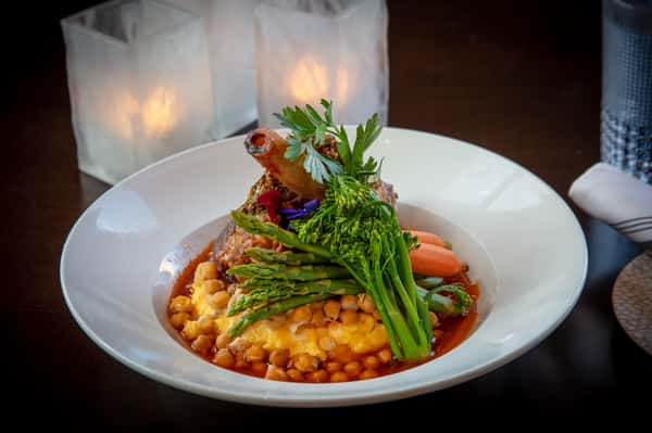 Braised beef served over creamy risotto with roasted asparagus and fresh herbs at Dulivia Ristorante Italiano in Springdale, Utah.