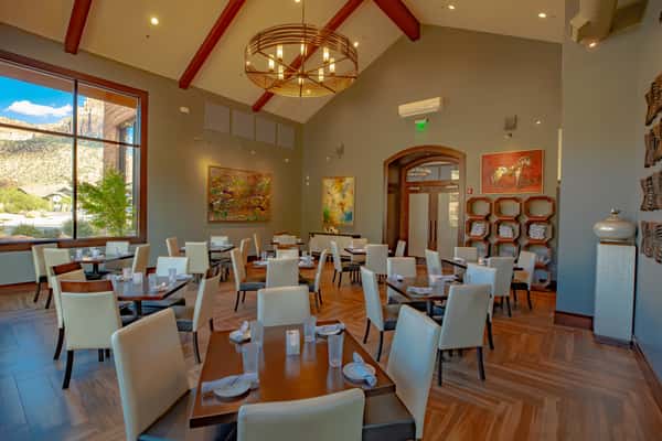 Elegant dining room at Dulivia Ristorante Italiano in Springdale, Utah, featuring warm lighting, contemporary artwork, and an upscale atmosphere for Italian dining and special occasions.